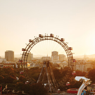 Riesenrad in Wien bei Sonnenuntergang mit Blick auf die Stadt.