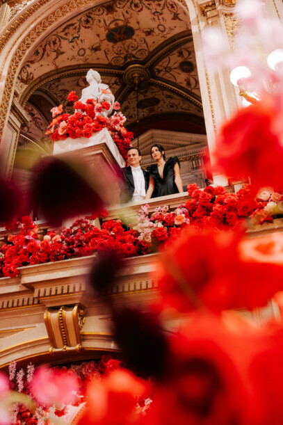 Two ball guests at the Vienna Opera Ball in the flower-adorned State Opera.