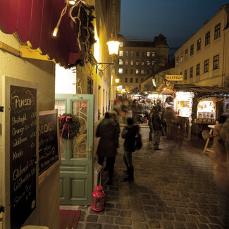 Festlich dekorierte Gasse mit Ständen am Weihnachtsmarkt Spittelberg.