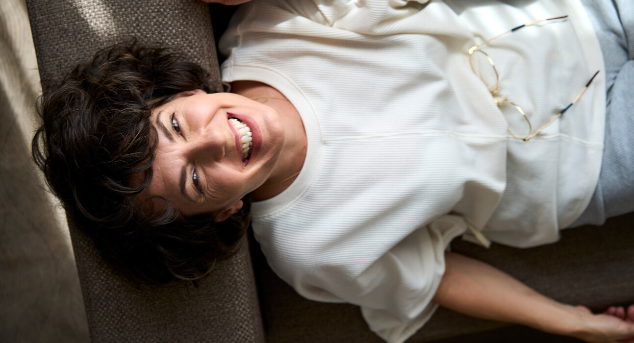 Laughing lady lying in bed at the 4* hotel Henriette near the Messe Wien Exhibition & Congress Center in Vienna.