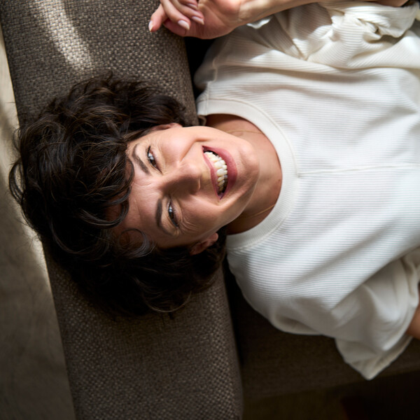 Laughing lady lying in bed at the 4* hotel Henriette near the Messe Wien Exhibition & Congress Center in Vienna.