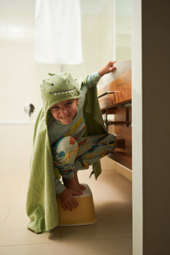 Un bambino allegro nel bagno della suite familiare dell’Henriette Stadthotel.