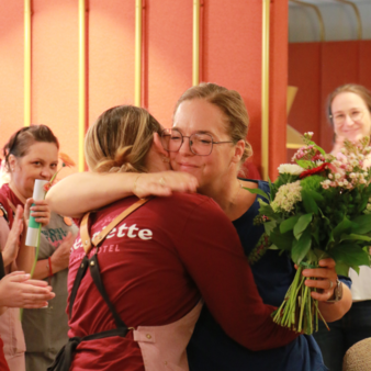 Forward thinker Verena hugs a colleague at the quarterly staff party.