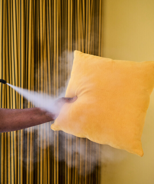 Employee cleaning an upholstery without chemical cleaning agents in the Boutique Hotel Henriette in Vienna.