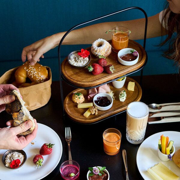Covered breakfast table with fresh juices, cheese, ham, bread in Henriette City Hotel