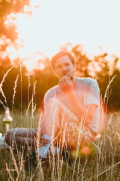 Ein junger Mann genießt ein Picknick bei Sonnenuntergang in Wien