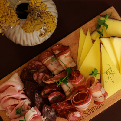 Eine große kalte Platte mit Fleisch, Wurst und Käse auf einem Holzbrett.