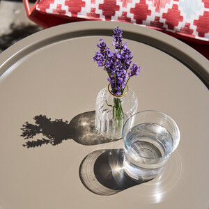 Vase mit Lavendel und Wasserglas auf einem Tisch im gay friendly Hotel Henriette in Wien.