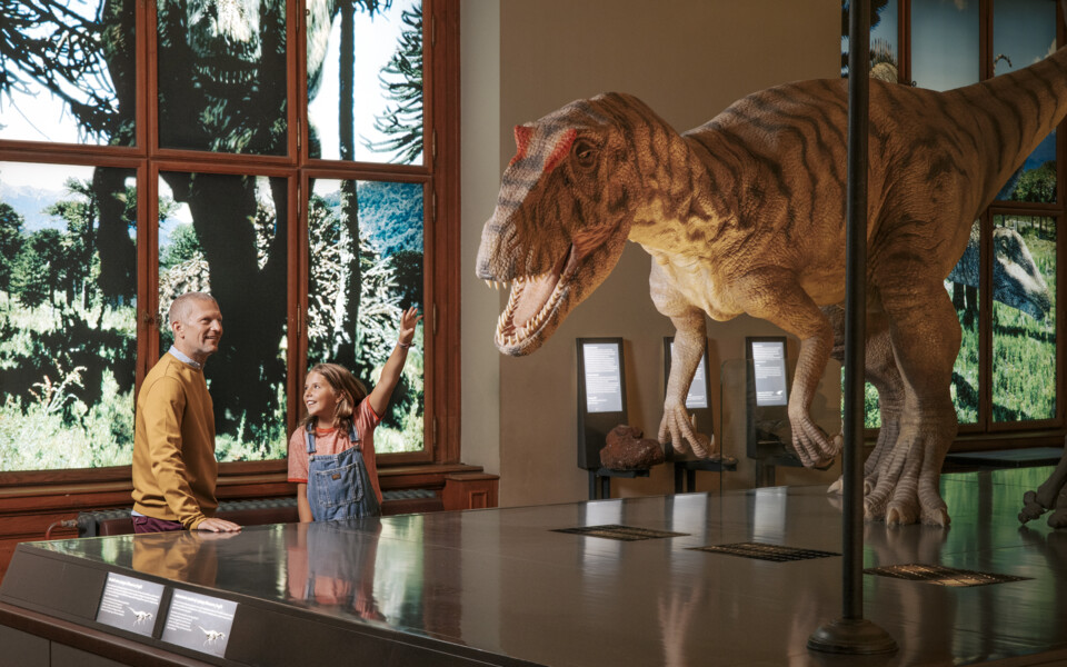 Girl pointing excitedly at a life-size dinosaur in the Natural History Museum Vienna – an outing included in the Vienna Explorer Package.