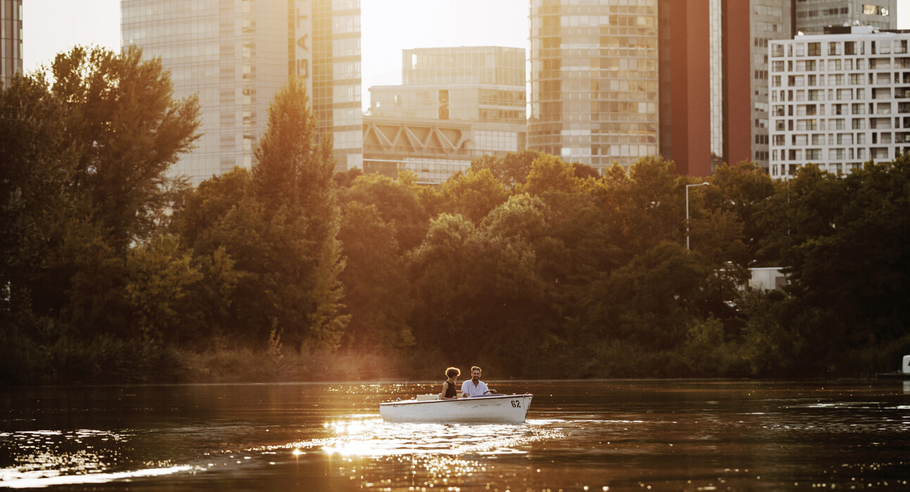 Pärchen beim Bootfahren im Sonnenuntergang auf der Alten Donau in Wien