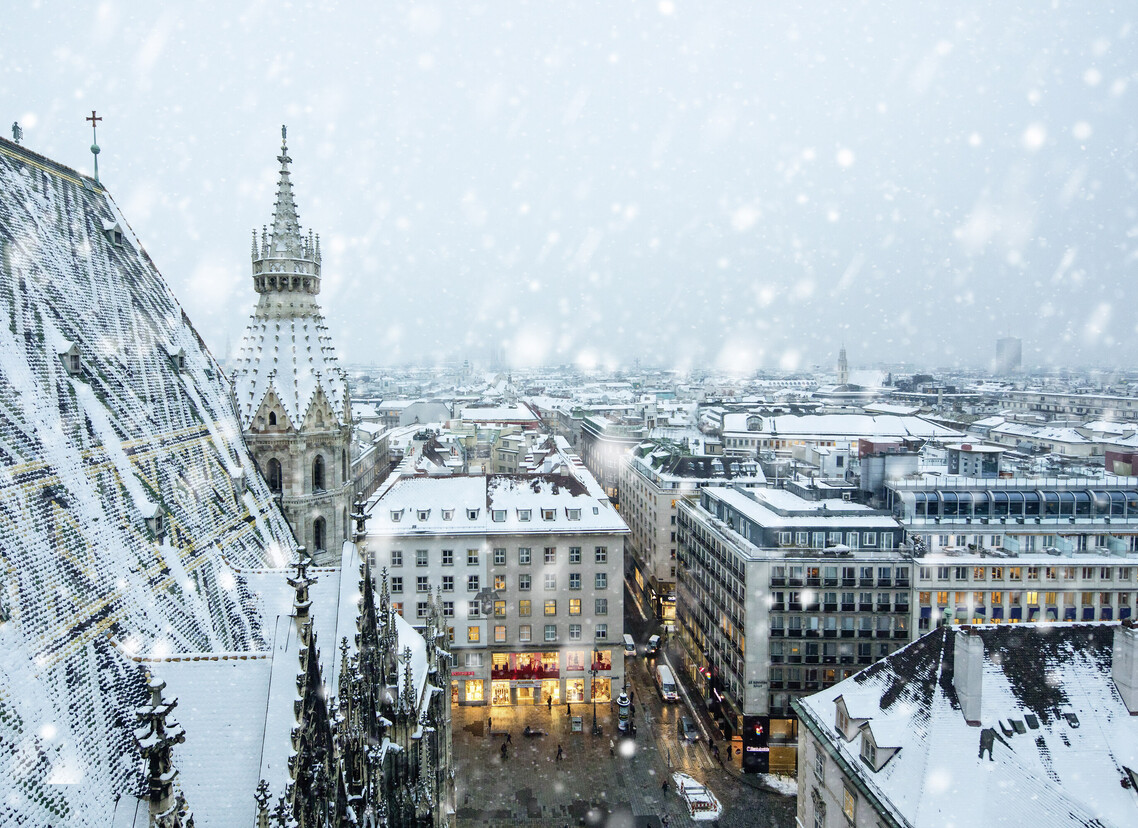 Blick auf den verschneiten Wiener Stephansdom und die Wiener Innenstadt zur Weihnachtszeit.