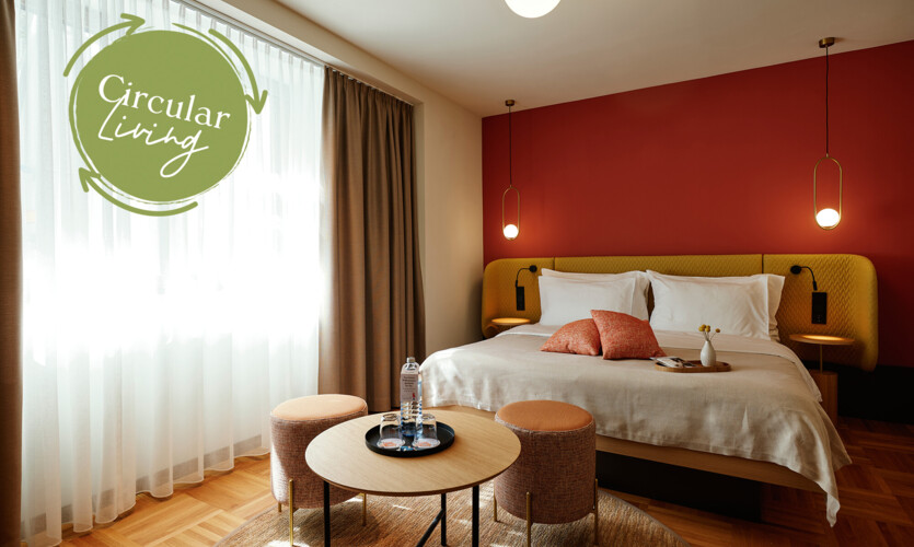 Einzigartiges Circular Living Zimmer mit Doppelbett und Parkettboden im Stadthotel Henriette in Wien.