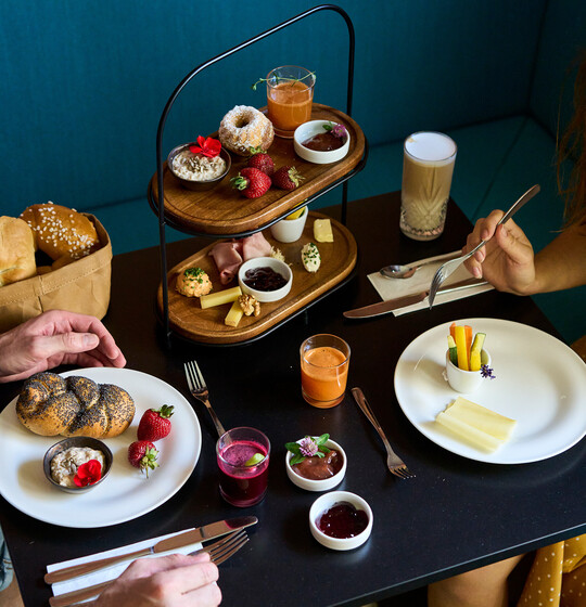 Gedeckter Tisch mit Frühstück, Gebäck, Säften im 4* Hotel Henriette in Wien.