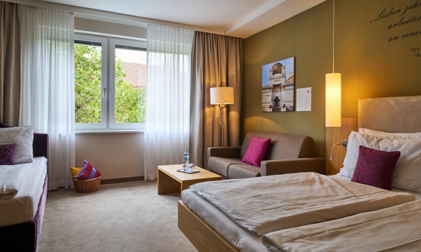 King Size Bett und Sofas im Familienzimmer im 4-Sterne Hotel Henriette im Zentrum von Wien.