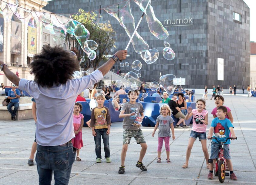 Kinder und Seifenblasenkünstler im MuseumsQuartier in Wien.