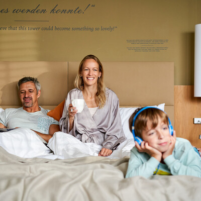 Familie beim Frühstücken im Bett im Henriette Stadthotel, Wien.