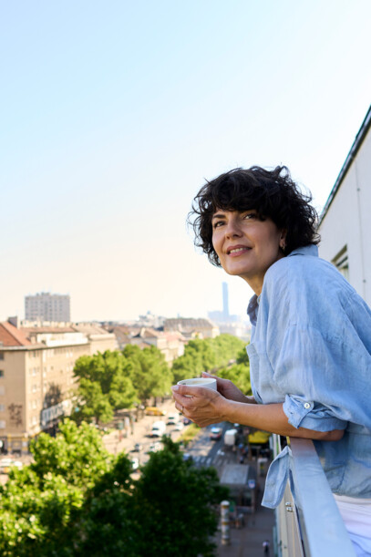 Dame am Balkon des Hotel Henriette in Wien - perfekt für einen Ausflug auf die Donauinsel.
