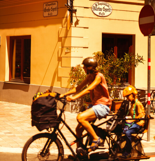 Woman and child on a bike on the corner of the Große and Kleine Sperlgasse in Vienna's 2nd district.