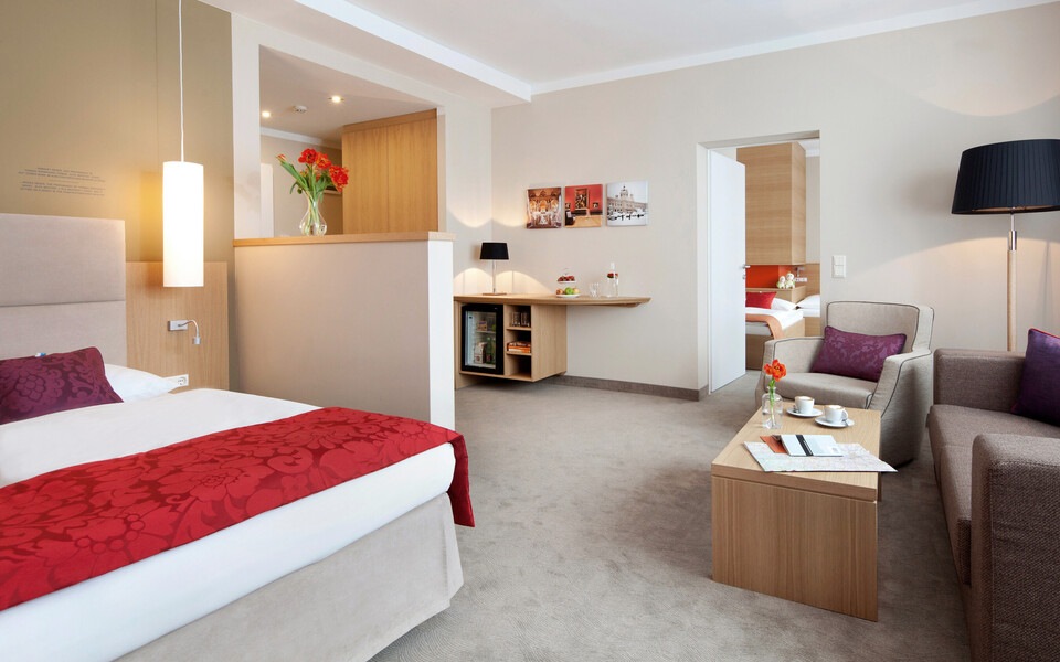 Spacious family suite with king-size bed and separate children's room at hotel Henriette in Vienna.