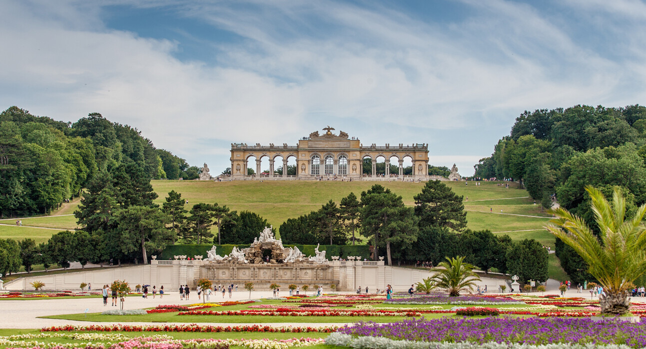 Enjoy spring in Vienna with 13% off: the Gloriette at Schönbrunn Palace above colorful spring flowerbeds in the Palace park.