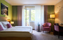 Großes Doppelzimmer mit Sitzgelegenheit und Balkon im Henriette Stadthotel in der Wiener Innenstadt.