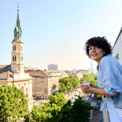 Lady on the balcony of the Hotel Henriette near the Messe Wien Exhibition & Congress Center.