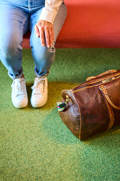 Lady with a travel bag in the lobby of the boutique hotel Henriette in Vienna.