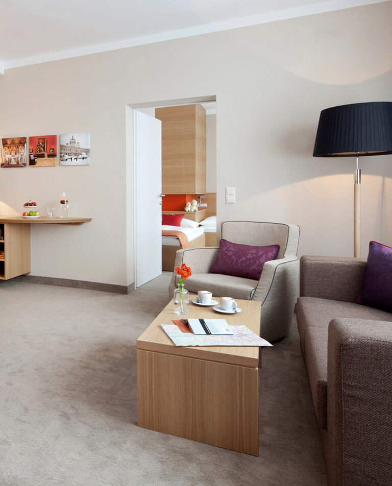 Modernes Hotelzimmer mit gemütlicher Sitzecke, Doppelbett und stilvollem Dekor im Henriette Stadthotel.