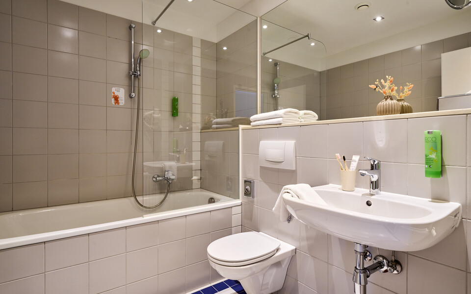 Badezimmer mit Badewanne im Familienzimmer im Hotel Henriette in Wien.
