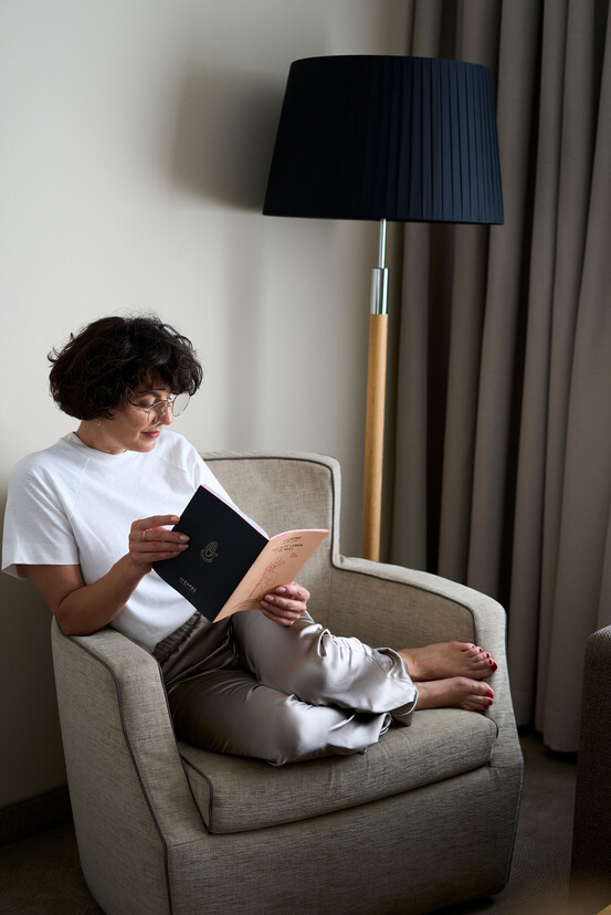 Dame beim Lesen in einem Couch-Sessel im 4* Henriette Stadthotel in Wien - ehemals Hotel Das Capri.