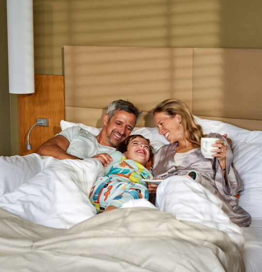 Eltern mit Kind im großzügigen Familienzimmer im Familienhotel Henriette in Wien.