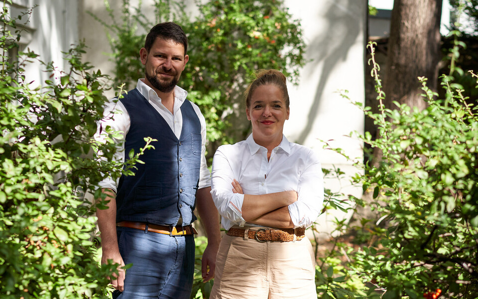 Verena und Georg Pastuszyn, Inhaber des Stadthotel Henriette, im Garten unter den Bäumen.