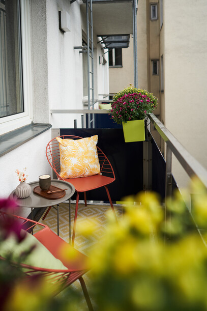  Balkon mit Sitzgelegenheit und Blumen im 4-Stern Hotel Henriette in Wien.