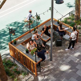 Der schöne Ernst: Menschen sitzen und genießen Sie Kaffee und Spritzer im Gastgarten.