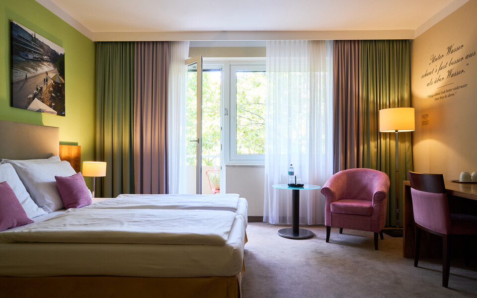 Großes Doppelzimmer mit Sitzgelegenheit und Balkon im Henriette Stadthotel in der Wiener Innenstadt.