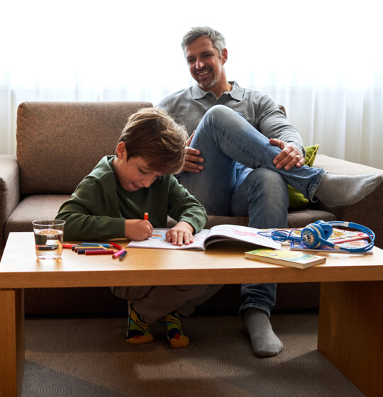 Vater und Sohn beim Spielen in den großzügigen Familienzimmern im Familienhotel Henriette in Wien.