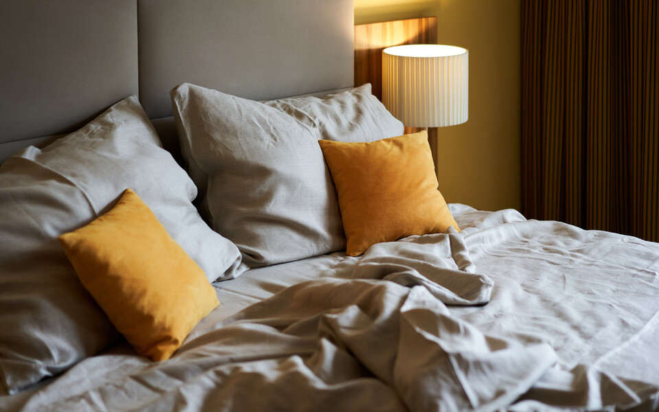 Gemütliches Bett mit Leinenbettwäsche für traumhaften Schlaf im Wiener Hotel Henriette