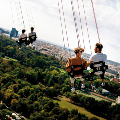 Menschen auf einem Kettenkarussell mit Blick über den Wiener Prater, nur 10 Gehminuten vom Hotel Henriette.