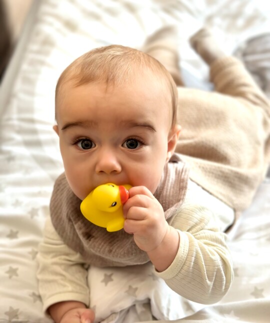 Ein Baby mit einer Spielzeugente