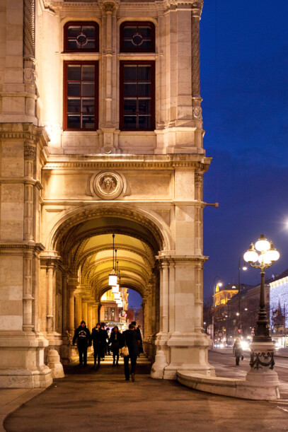 Two ball guests at the Vienna Opera Ball in the flower-adorned State Opera.