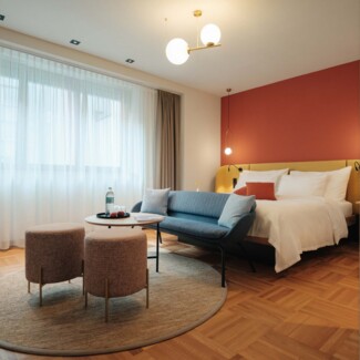 Pärchen beim Entspannen im gemütlichen Doppelbett bei einer Städtereise nach Wien.