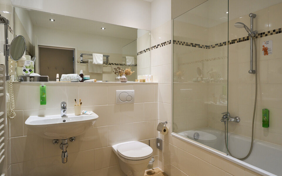 Badezimmer mit Badewanne im Familienzimmer im Henriette Stadthotel, Wien.