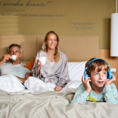 Familie beim Frühstücken im Bett im Henriette Stadthotel, ein Hotel nahe dem Prater in Wien.