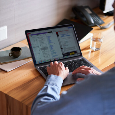 Man with a laptop at a desk in the business hotel Henriette, near the Messe Wien Exhibition & Congress Center.