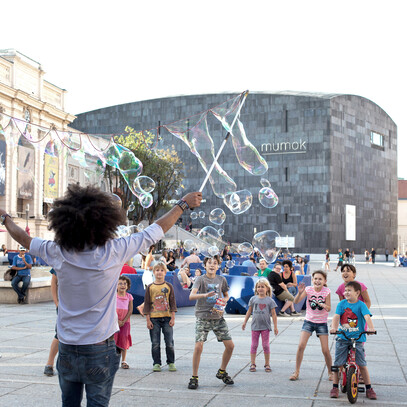 Kinder mit Seifenblasen-Künstler vor dem MuseumsQuartier in Wien