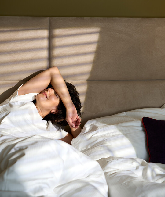 Lady getting awake in the comfortable beds in the Boutique Hotel Henriette, Vienna.
