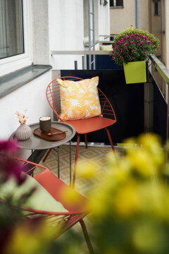Gemütlich gestalteter Balkon mit Sitzmöglichkeiten und Blumen im Stadthotel Henriette in Wien.