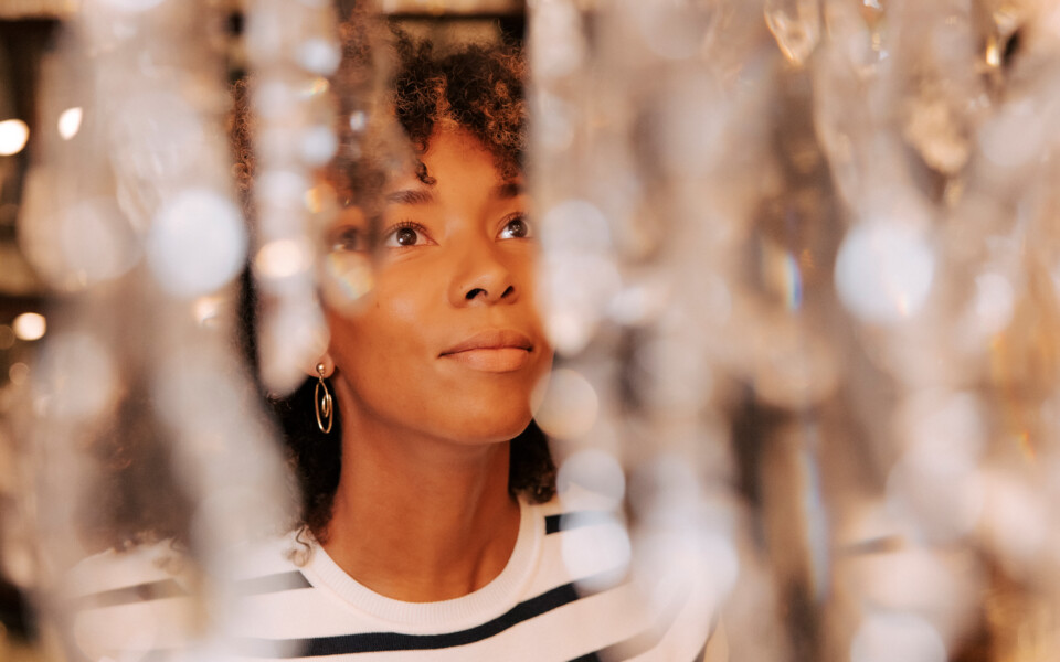 A woman admiring a chandelier at Lobmeyr, Vienna: enjoy a 13% November bonus to brighten the autumn blues.