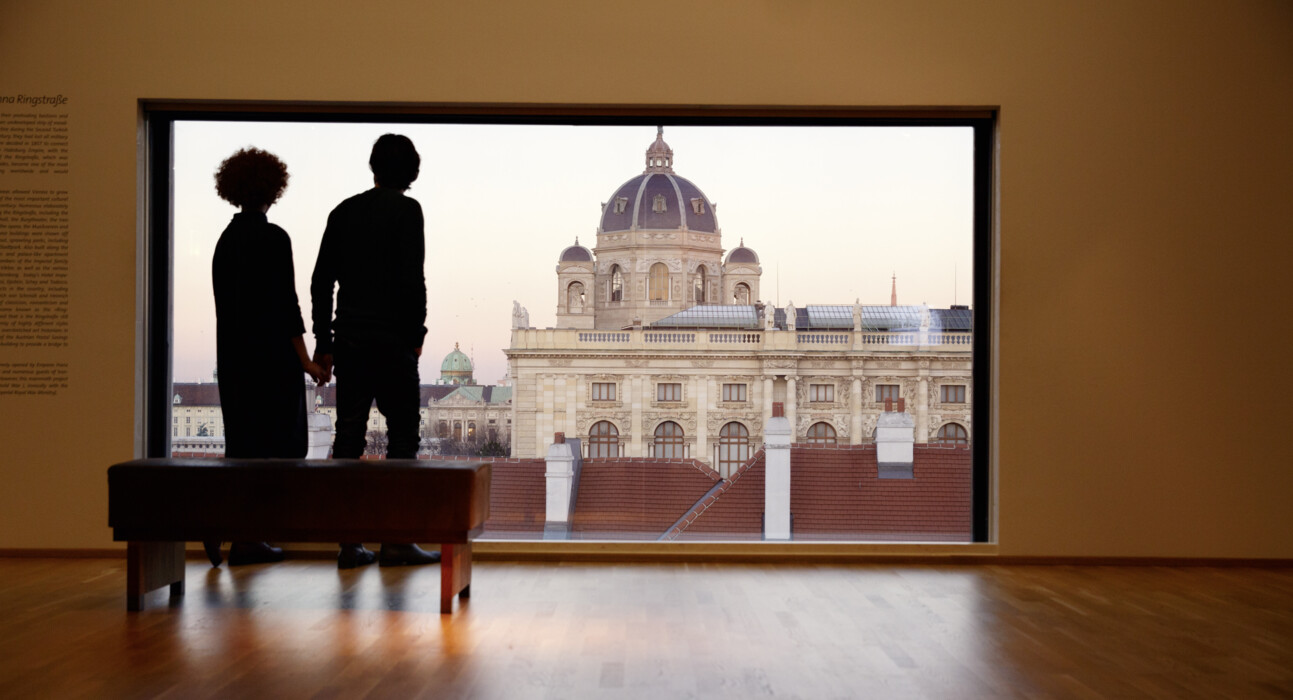 A couple enjoying the view from the panoramic window of the Leopold Museum towards the Kunsthistorisches Museum in Vienna.