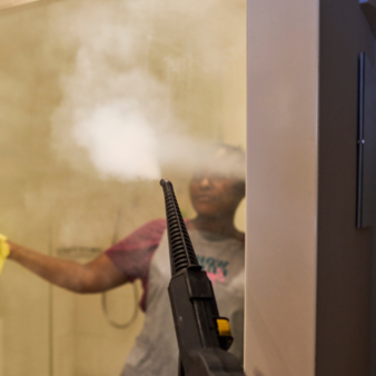 A wellness expert cleans the bathroom using chemical-free micro-dry steam.
